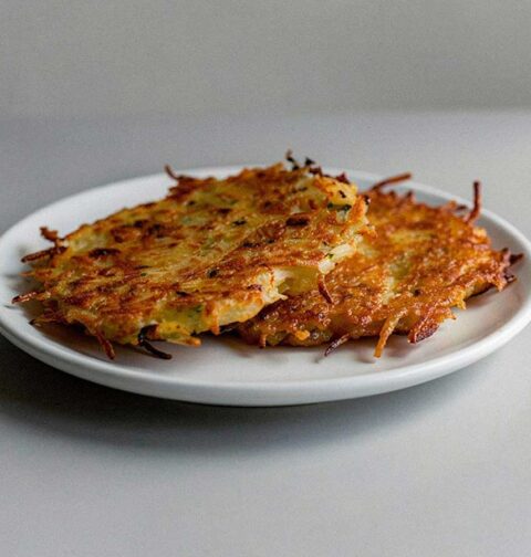 2 net gebakken aardappelpannenkoeken op een wit bordje.