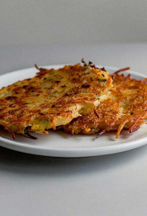 2 net gebakken aardappelpannenkoeken op een wit bordje.
