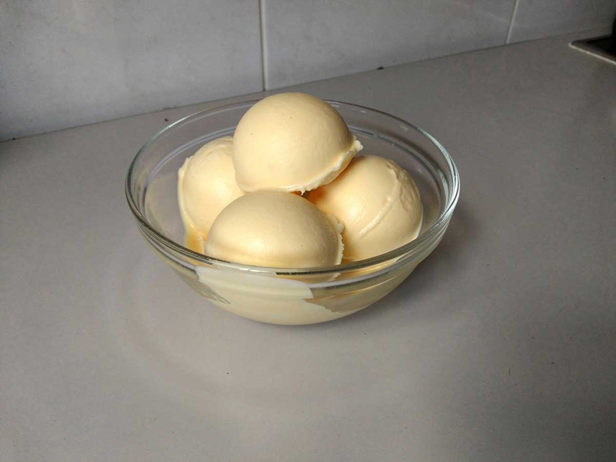 4 bollen zelfgemaakt advocaaat roomijs in een glazen schaaltje.