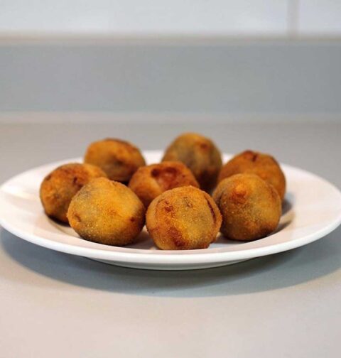 Een bordje met daarop 8 gefrituurde bitterballen.