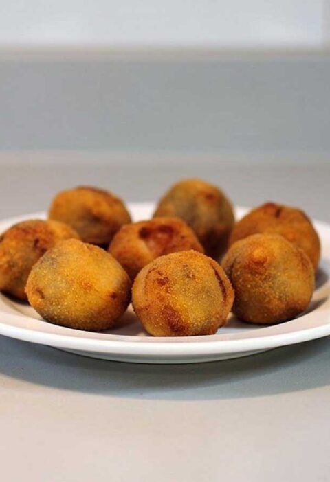 Een bordje met daarop 8 gefrituurde bitterballen.