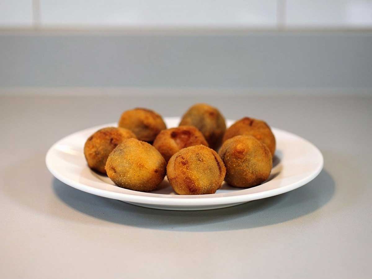 Een bordje met daarop 8 gefrituurde bitterballen.