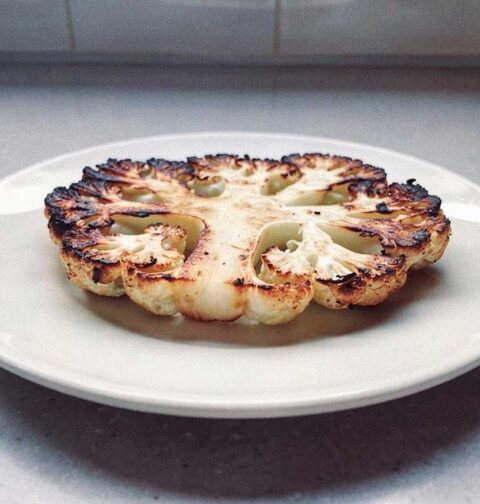 Een gegrildebloemkoolsteak op een bord, iets te hard gegaan.