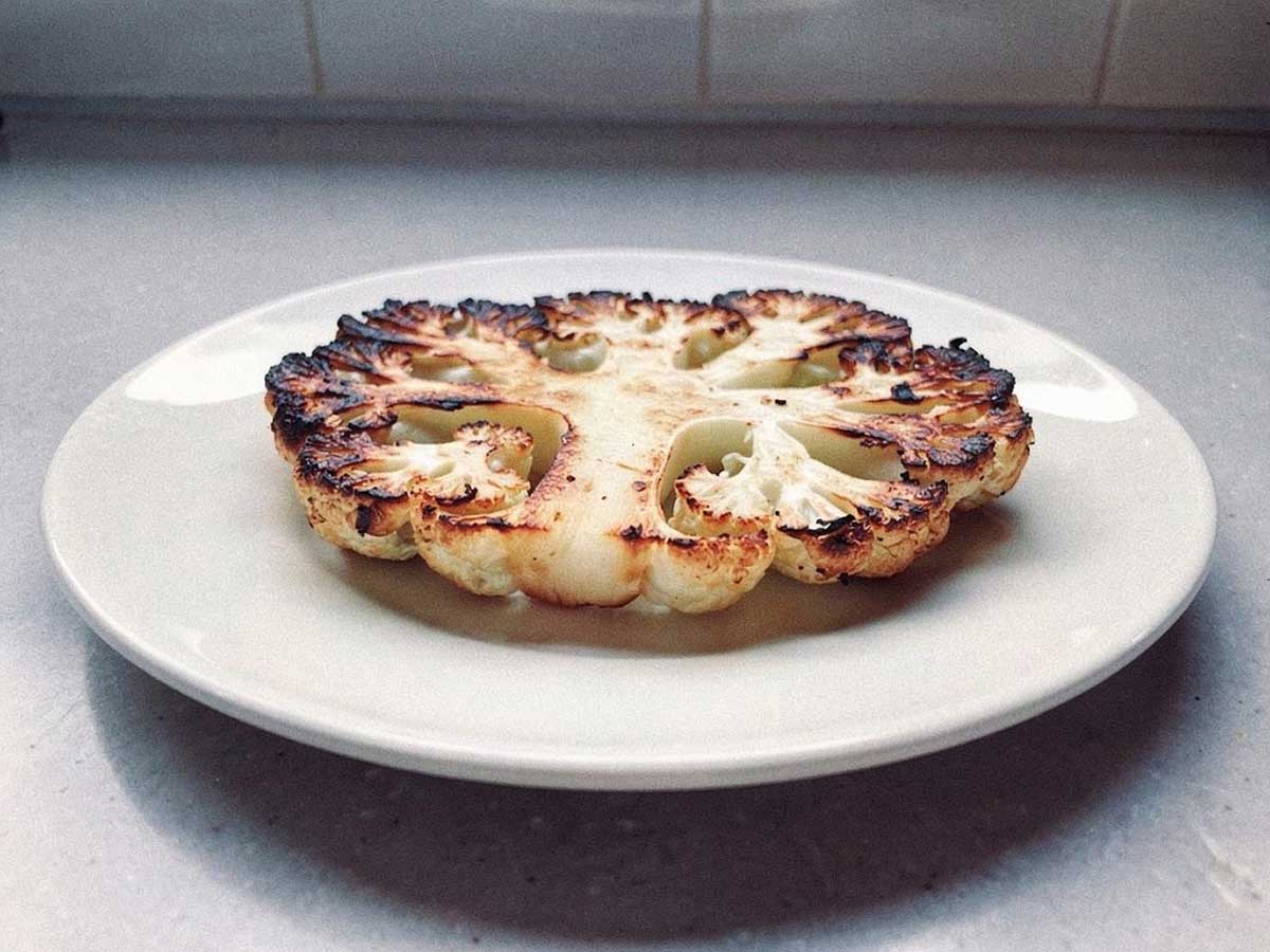 Een gegrildebloemkoolsteak op een bord, iets te hard gegaan.