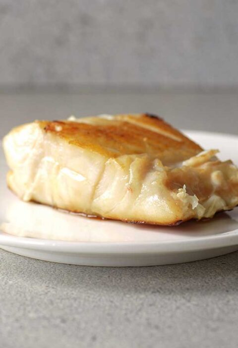 Een gebakken botervis (filet) op een wit bordje.