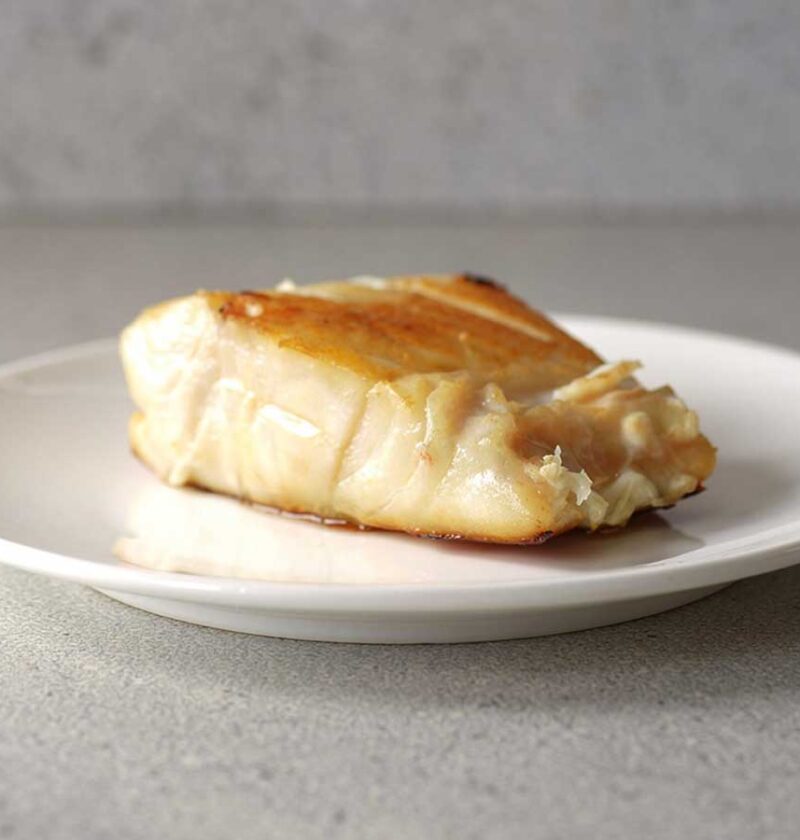 Een gebakken botervis (filet) op een wit bordje.