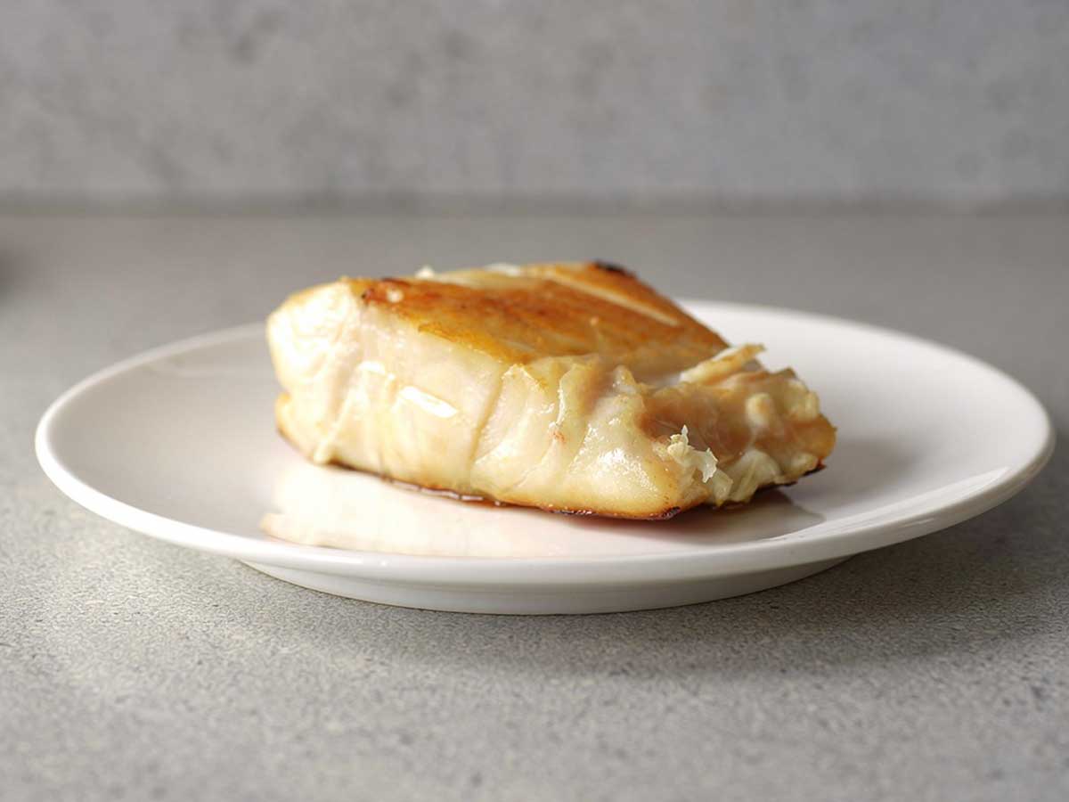Een gebakken botervis (filet) op een wit bordje.