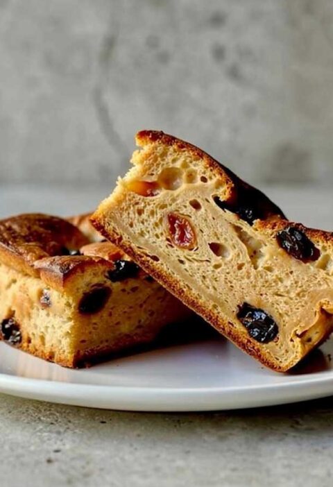 2 stukken broodpudding op een wit bordje.