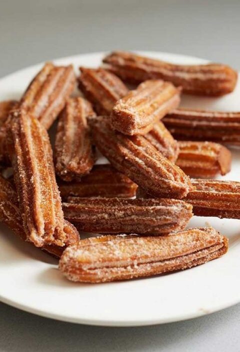 13 churros op en wit bordje, nog zonder suiker.
