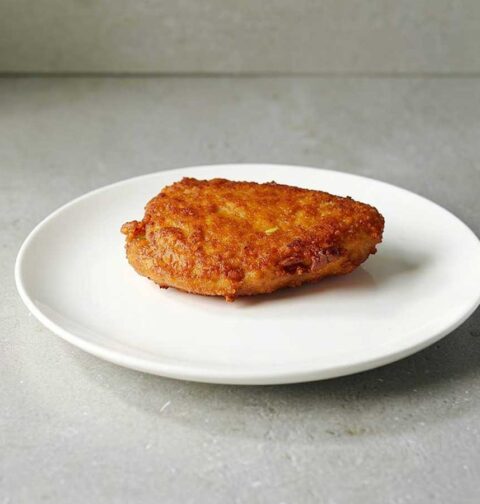 Een gebakken cordon bleu op een wit bord.
