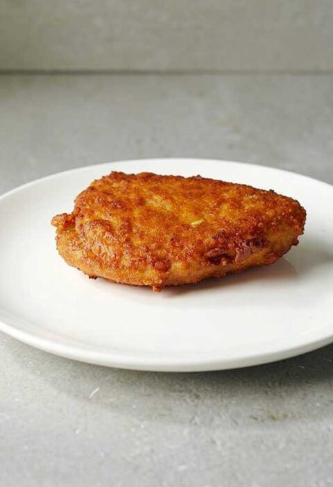 Een gebakken cordon bleu op een wit bord.