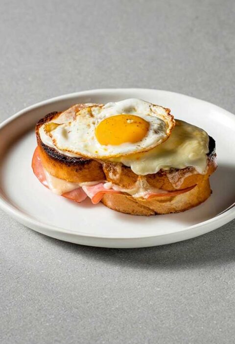 Een Croque Madame op een wit bordje.