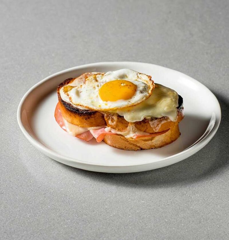 Een Croque Madame op een wit bordje.