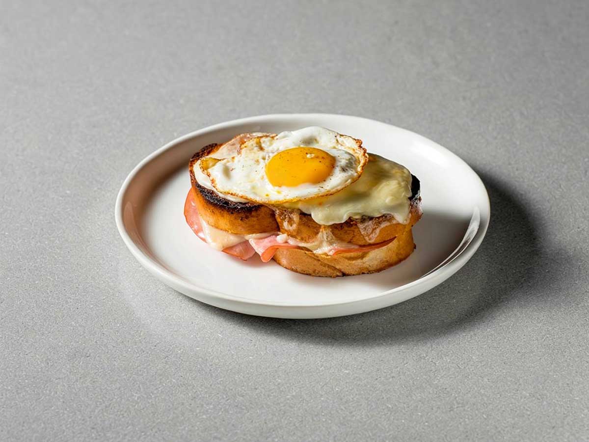 Een Croque Madame op een wit bordje.