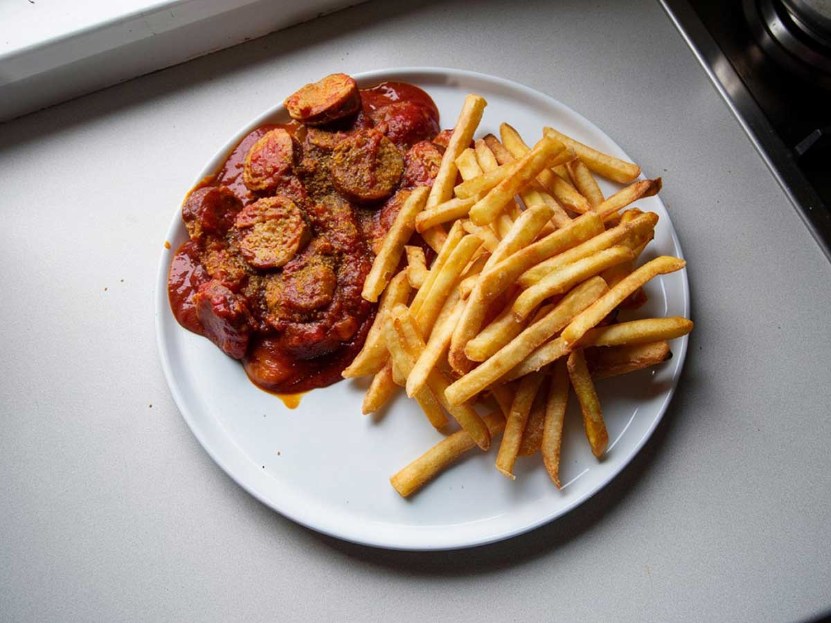 Duitse curryworst met franse frietjes.