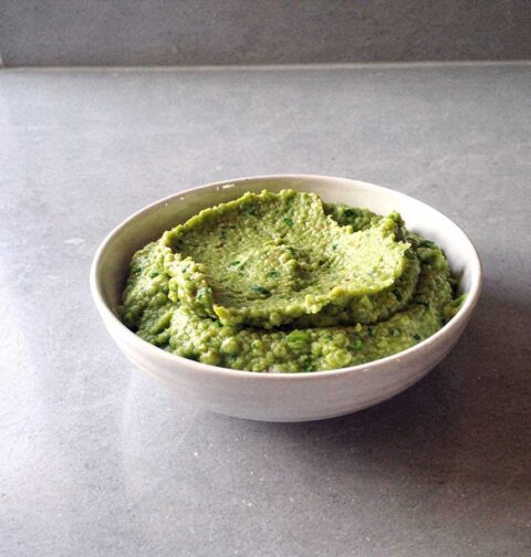 Een schaaltje met grof gepureerde erwtenpuree.