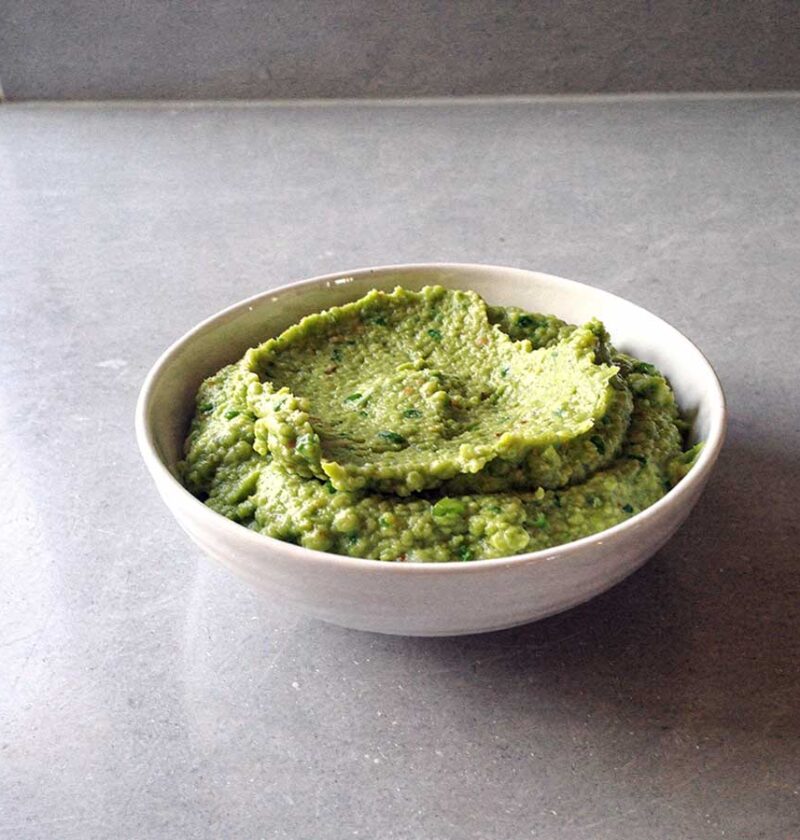 Een schaaltje met grof gepureerde erwtenpuree.