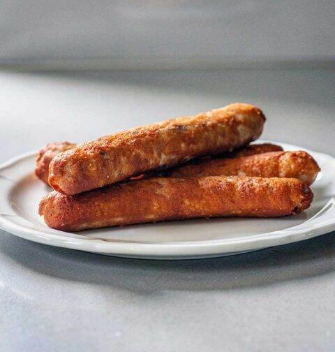 4 zelfgemaakte frikandellen op een bordje om op te warmen.