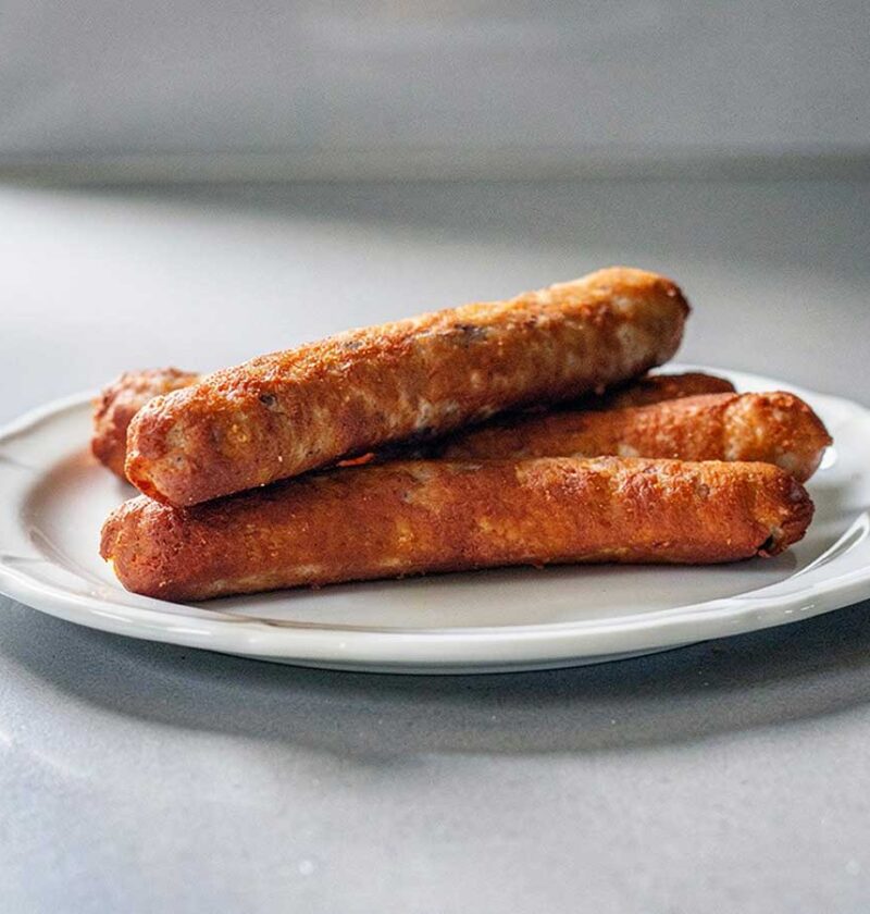 4 zelfgemaakte frikandellen op een bordje om op te warmen.