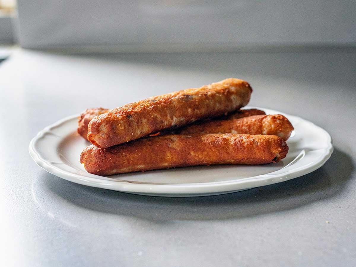 4 zelfgemaakte frikandellen op een bordje om op te warmen.