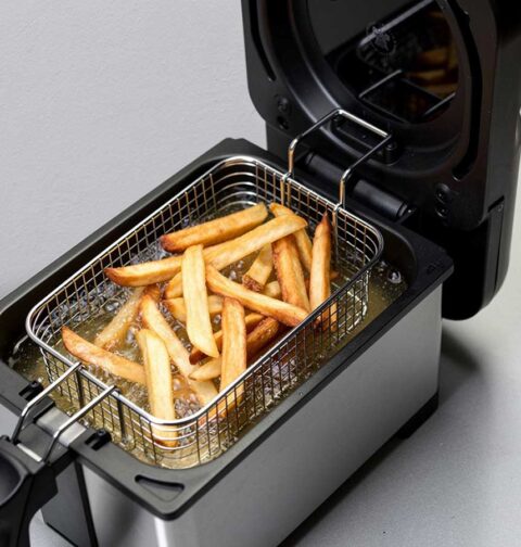 Een friteuse waarin net patat gefrituurd is.