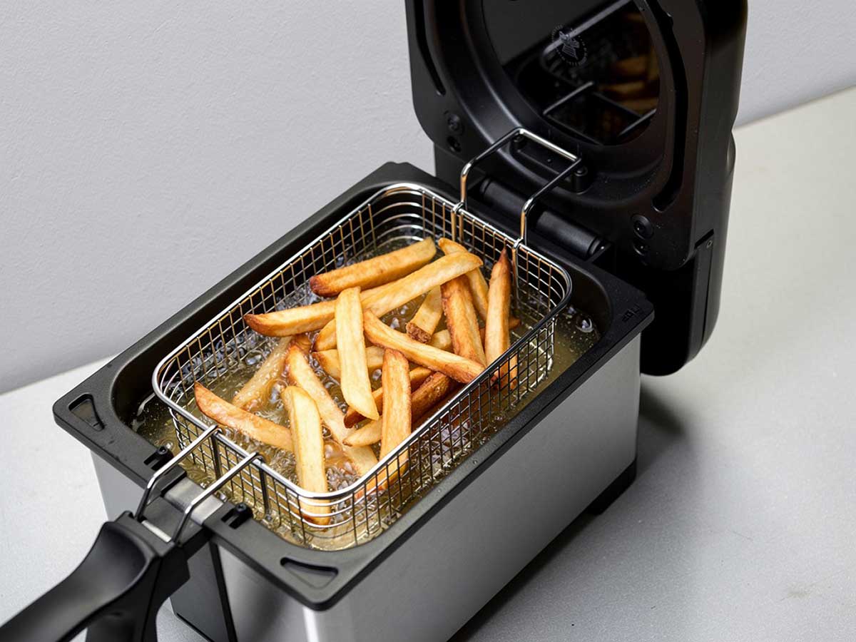 Een friteuse waarin net patat gefrituurd is.
