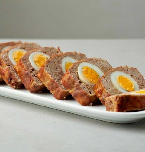 Een in plakken gesneden gehaktbrood, met daarin gekookte eieren.