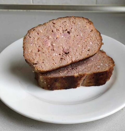 2 plakken zelfgemaakt en gebakken gehaktbrood op een wit bord.