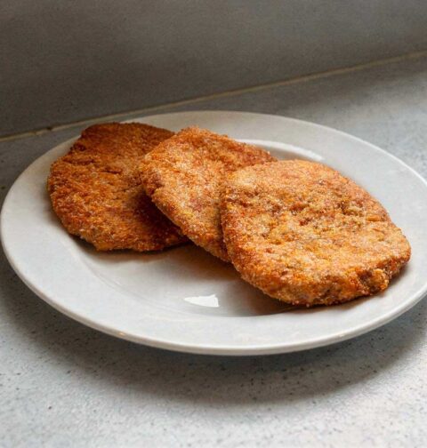 3 gehaktschnitzel op een wit bord.