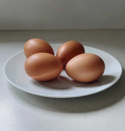 4 gekookte eieren op een bord, voordat ze opgewarmd worden.