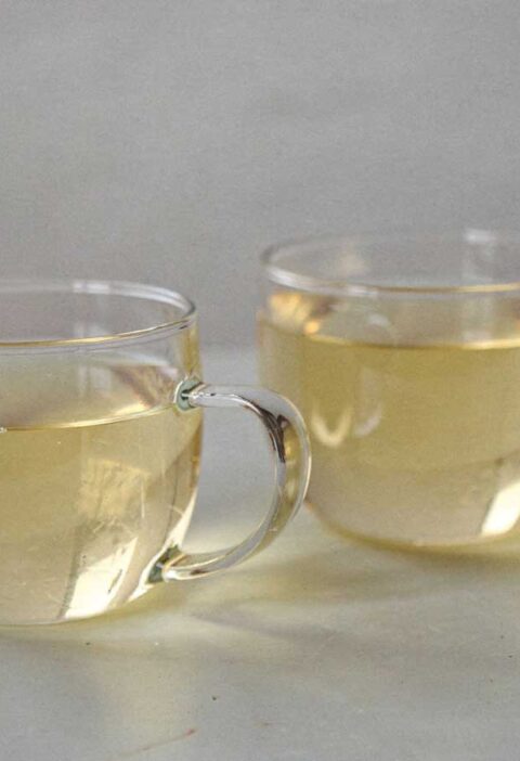 2 ronde theeglazen met daarin gemberthee met citroen.