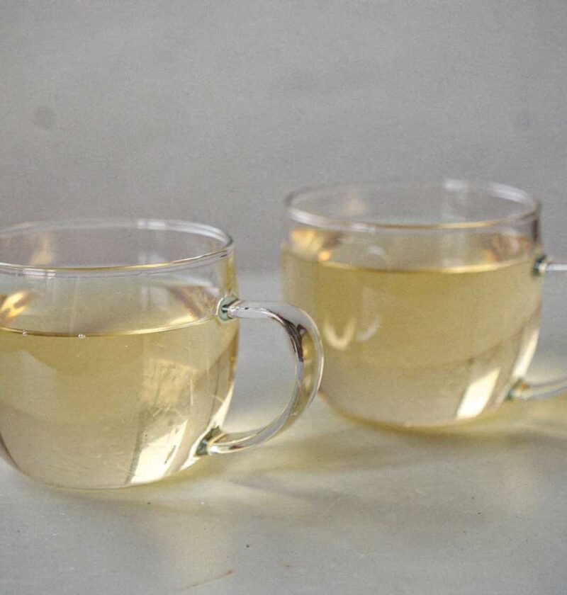 2 ronde theeglazen met daarin gemberthee met citroen.