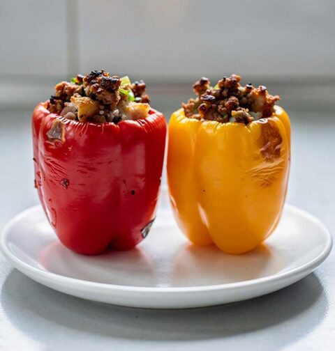 2 gevulde paprika's (rood en geel) staan klaar om op te warmen.