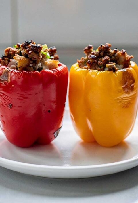 2 gevulde paprika's (rood en geel) staan klaar om op te warmen.