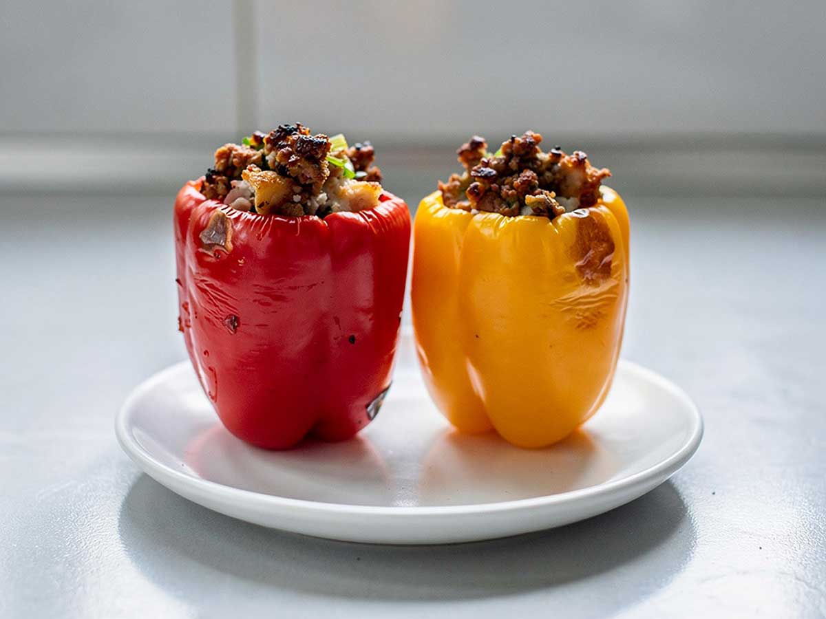 2 gevulde paprika's (rood en geel) staan klaar om op te warmen.