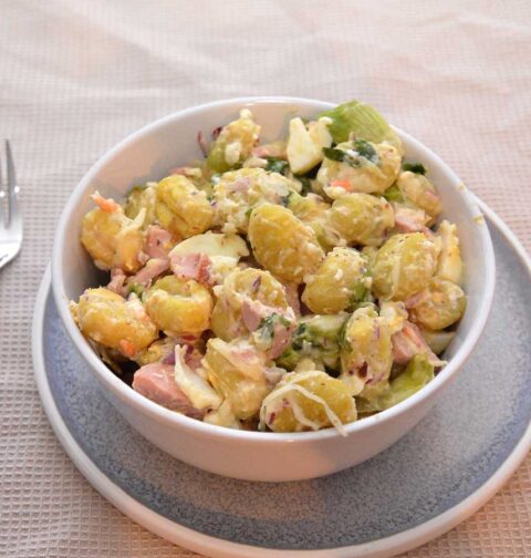 Een salade met gekookte gnocchi, in een wit schaaltje.