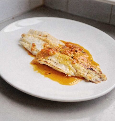 Een gebakken grietfilet op een wit bord.
