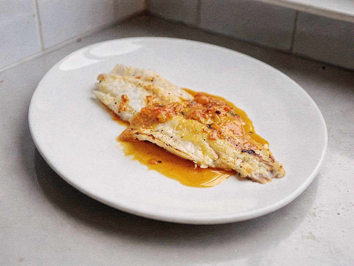 Een gebakken grietfilet op een wit bord.