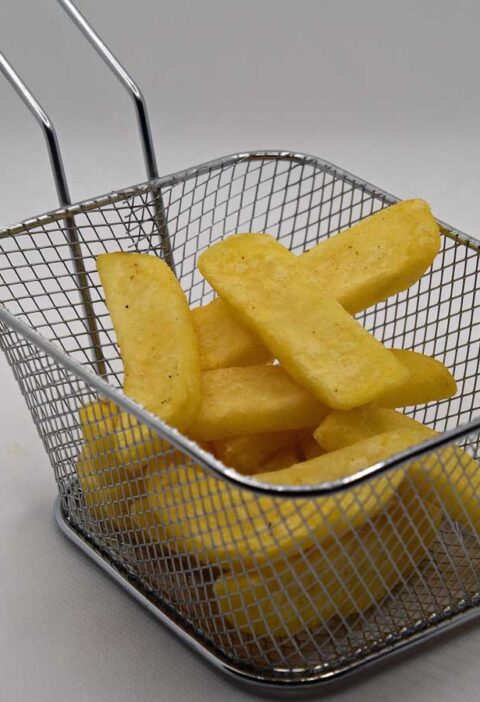 Een portie patat in een frituurmandje.