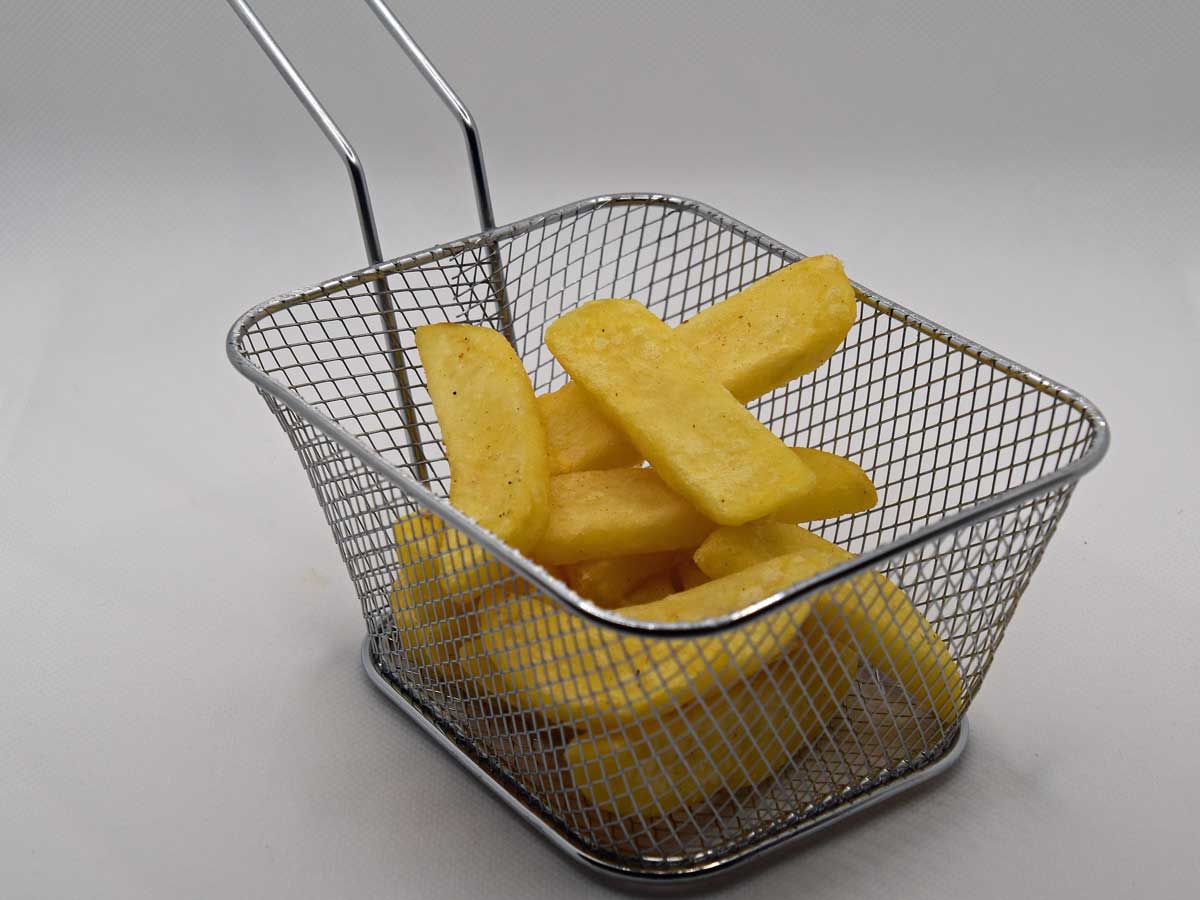 Een portie patat in een frituurmandje.