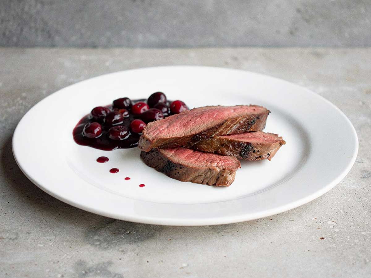 Drie plakjes hertenbiefstuk met een kersenchutney.