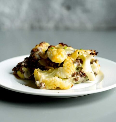 Een portie Hollandse ovenschotel met bloemkool op een wit bord.