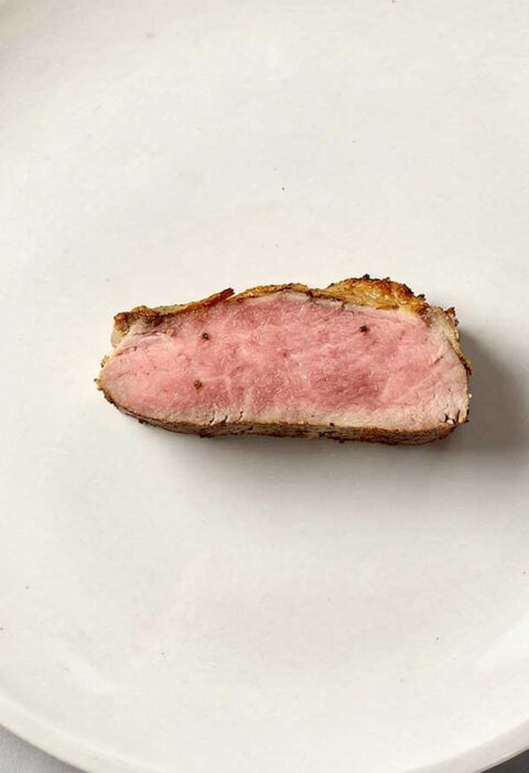 Een plakje kalfsoester, zielig alleen in het midden van een groot bord.