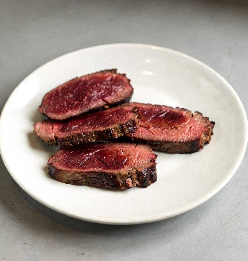 4 gebakken kangoeroes steaks op een wit bord.