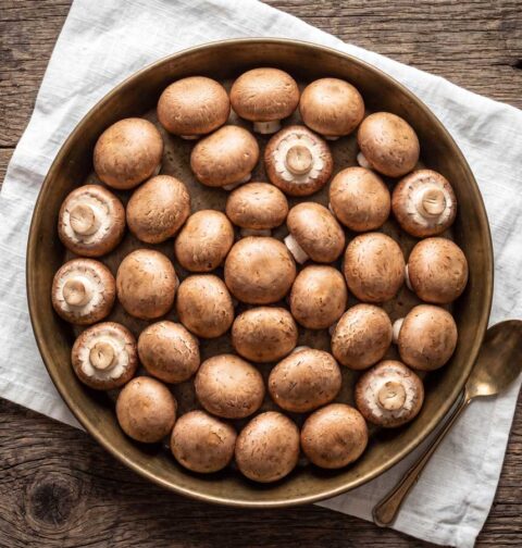 Kastanjechampignons bakken, maar eerst goed schoonboenen. Wilhelmus Hengstmengel doet dat met een stukje keukenpapier.