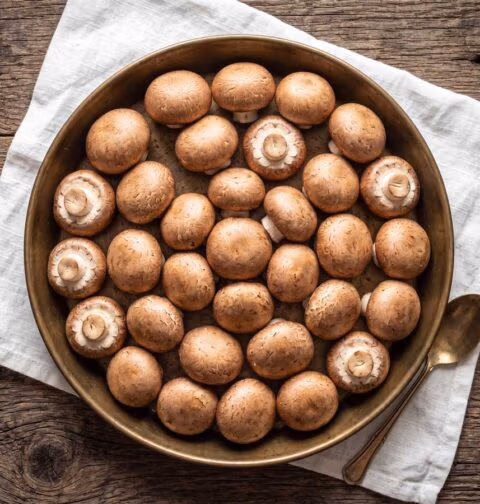 Kastanjechampignons bakken, maar eerst goed schoonboenen. Wilhelmus Hengstmengel doet dat met een stukje keukenpapier.