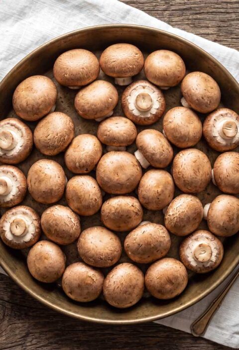 Kastanjechampignons bakken, maar eerst goed schoonboenen. Wilhelmus Hengstmengel doet dat met een stukje keukenpapier.