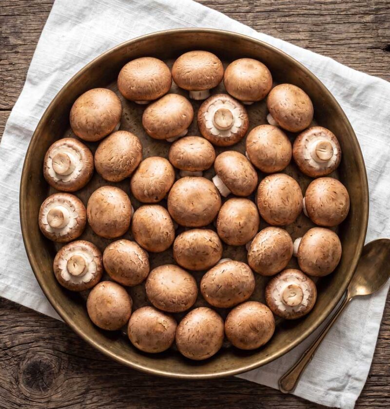 Kastanjechampignons bakken, maar eerst goed schoonboenen. Wilhelmus Hengstmengel doet dat met een stukje keukenpapier.