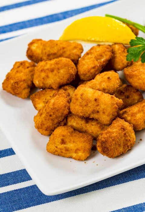 Gebakken kibbeling op een witte schaal.
