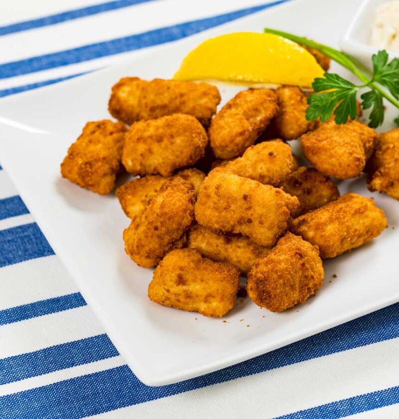 Gebakken kibbeling op een witte schaal.